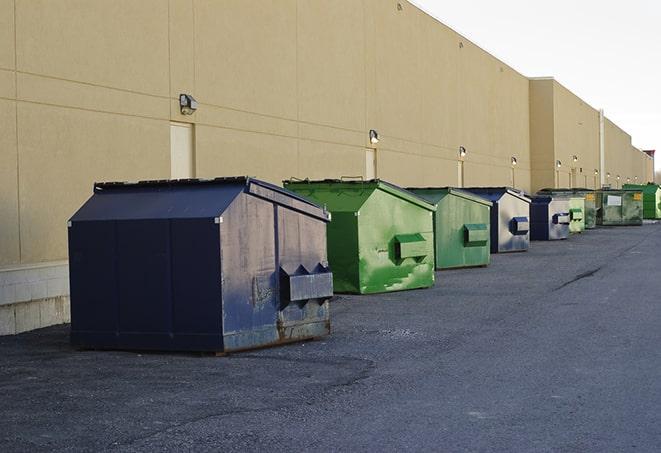 tilted front-load dumpsters being emptied by waste management workers in Au Train, MI